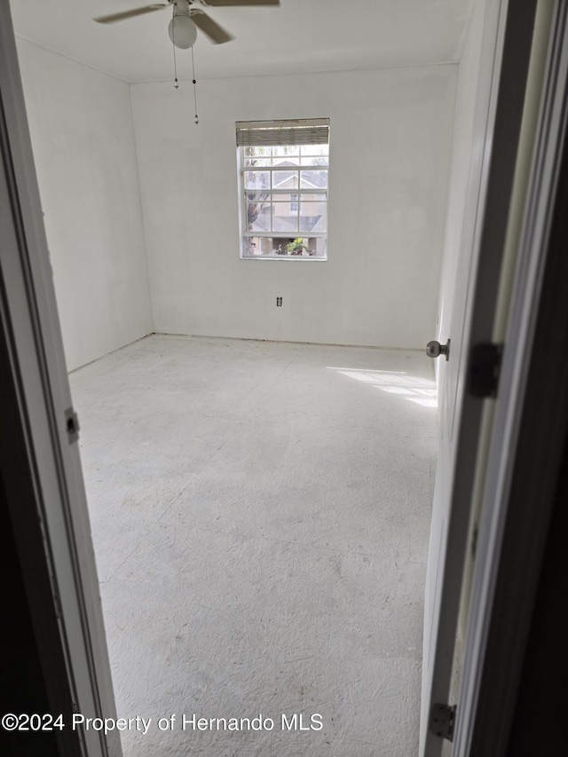 carpeted spare room with ceiling fan