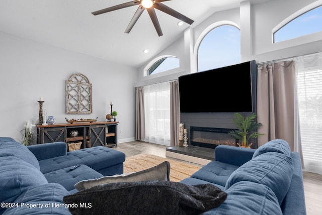 living room with high vaulted ceiling, light hardwood / wood-style floors, and ceiling fan