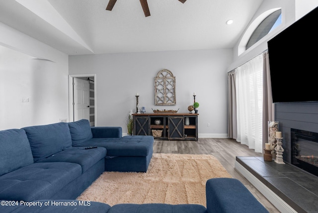 living room featuring hardwood / wood-style floors, lofted ceiling, and ceiling fan