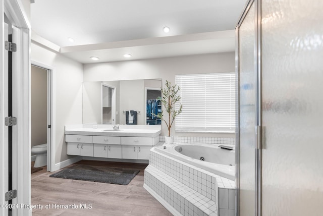 full bathroom featuring toilet, plus walk in shower, vanity, and hardwood / wood-style flooring