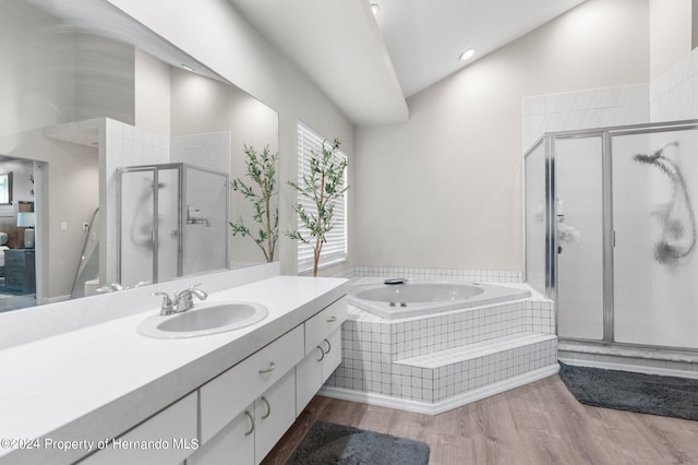 bathroom with hardwood / wood-style floors, vanity, lofted ceiling, and plus walk in shower