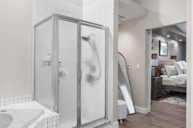 bathroom featuring hardwood / wood-style flooring and plus walk in shower