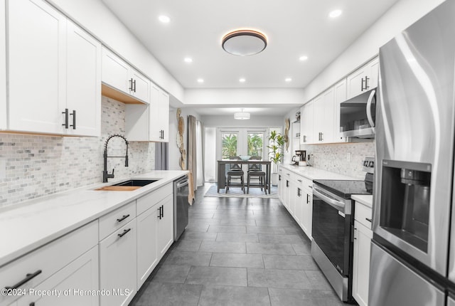 kitchen with white cabinetry, stainless steel appliances, and sink