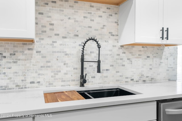 kitchen with dishwasher, sink, decorative backsplash, and white cabinets