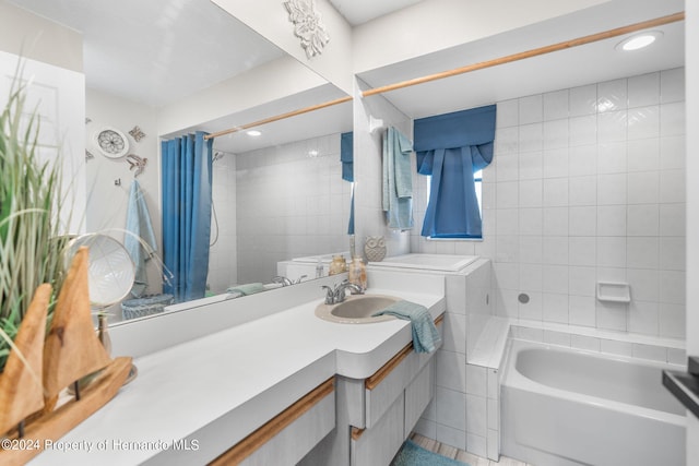 bathroom featuring tile patterned flooring, vanity, tile walls, and tiled shower / bath combo