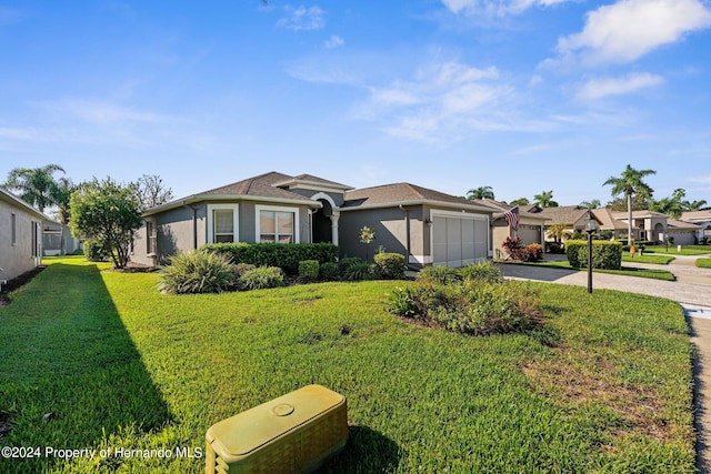 single story home with a garage and a front lawn