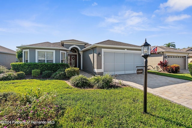 ranch-style house with a garage and a front yard