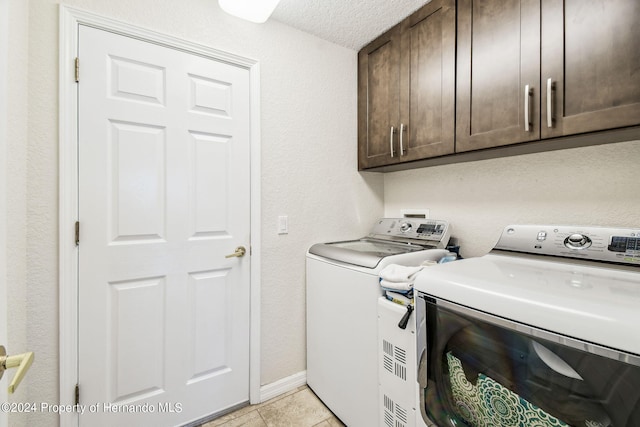 washroom featuring a textured ceiling, cabinets, independent washer and dryer, and light tile patterned flooring