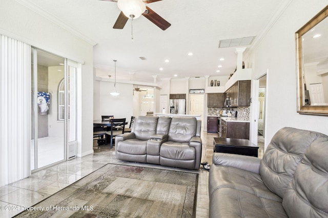 living room with ceiling fan and ornamental molding