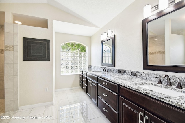 bathroom with vanity, lofted ceiling, and tile patterned flooring