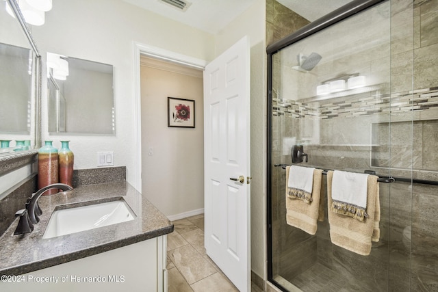 bathroom with an enclosed shower, vanity, and tile patterned floors