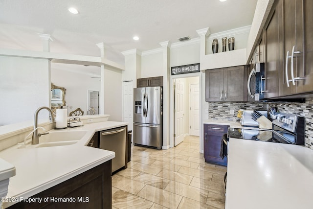 kitchen with stainless steel appliances, dark brown cabinetry, sink, ornamental molding, and backsplash