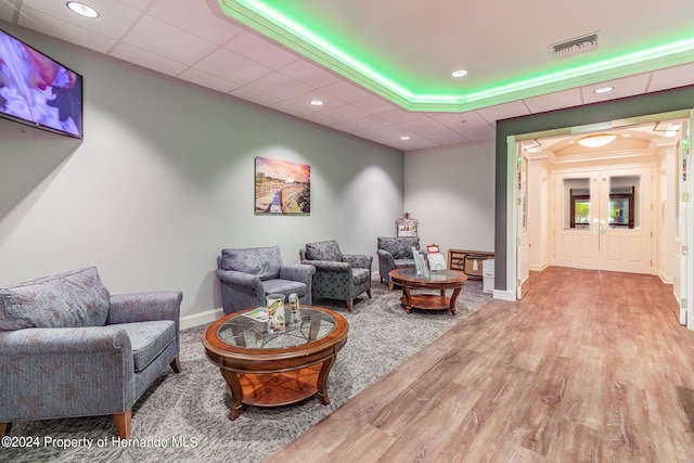 living area featuring hardwood / wood-style floors and a drop ceiling