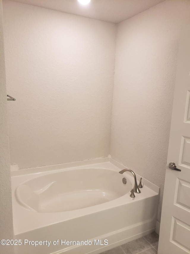 full bath with tile patterned flooring and a bath