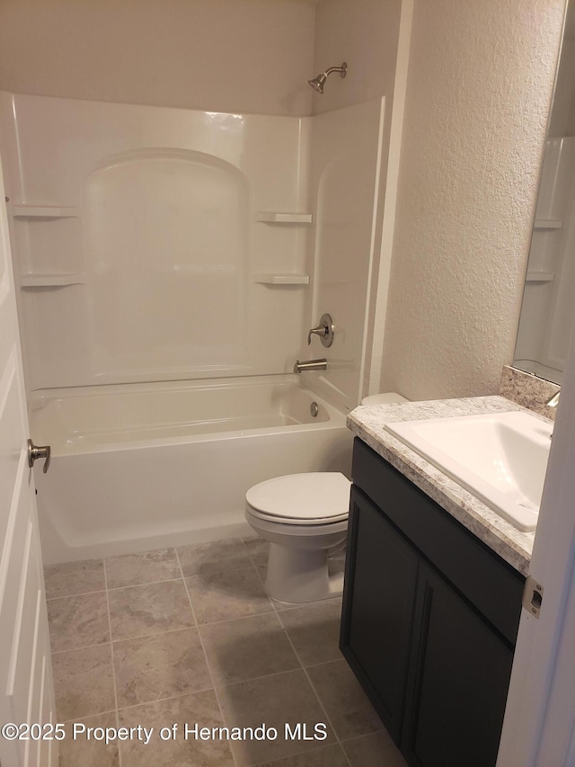 bathroom with bathtub / shower combination, a textured wall, toilet, vanity, and tile patterned floors