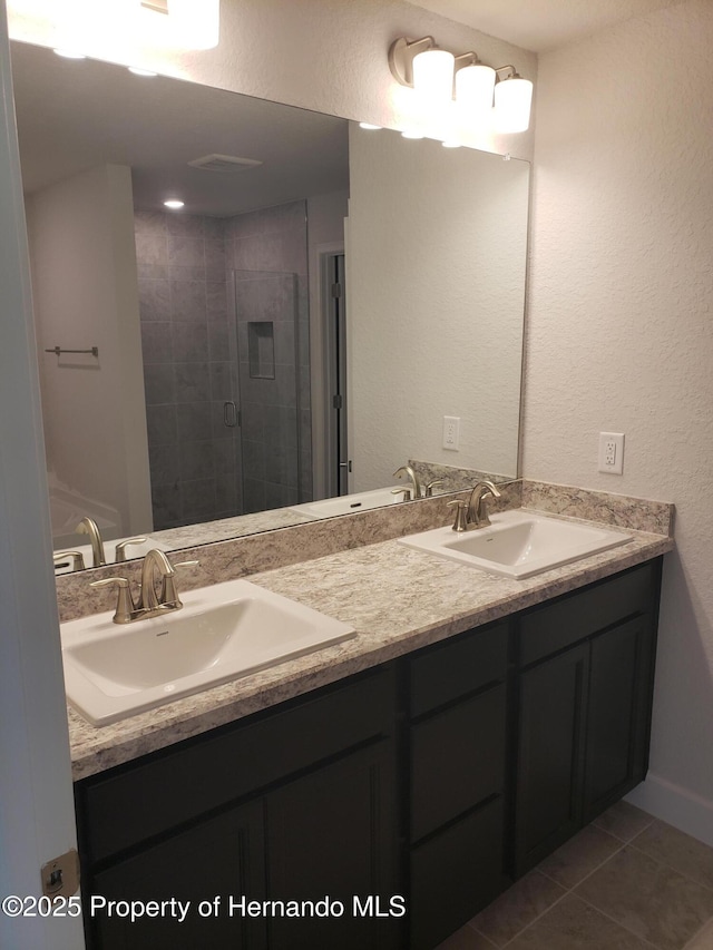 bathroom featuring a sink, a shower stall, and double vanity