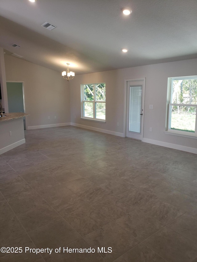 unfurnished living room featuring recessed lighting, visible vents, a notable chandelier, and baseboards