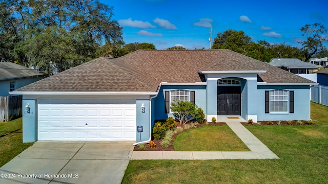 ranch-style home with a garage and a front lawn