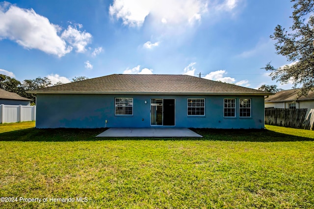 back of property with a yard and a patio area