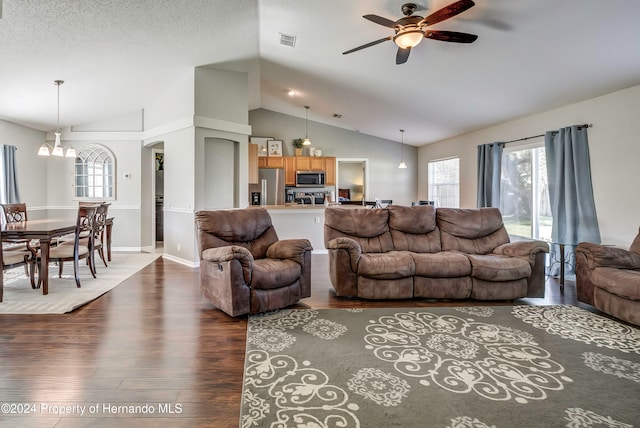 living room featuring a wealth of natural light, lofted ceiling, ceiling fan, and dark hardwood / wood-style flooring