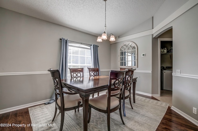 dining area with washer and clothes dryer, wood-type flooring, a notable chandelier, and a textured ceiling