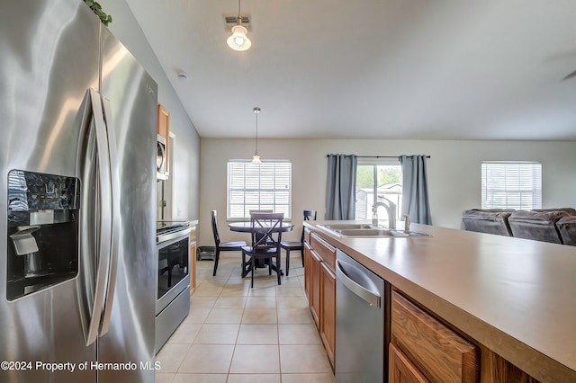 kitchen featuring hanging light fixtures, sink, light tile patterned flooring, and stainless steel appliances