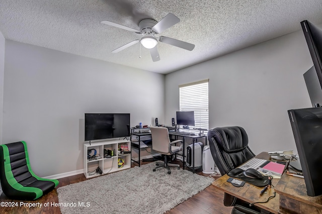 office area with ceiling fan, dark hardwood / wood-style floors, and a textured ceiling