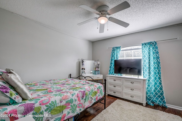 bedroom featuring dark hardwood / wood-style flooring, a textured ceiling, and ceiling fan