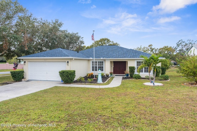 ranch-style home featuring a garage and a front lawn