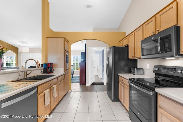 kitchen featuring stainless steel appliances, sink, light brown cabinetry, and light tile patterned floors