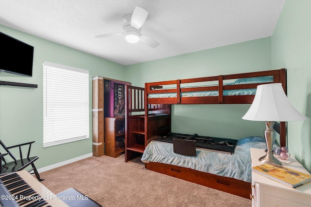 bedroom featuring ceiling fan, a textured ceiling, and light carpet