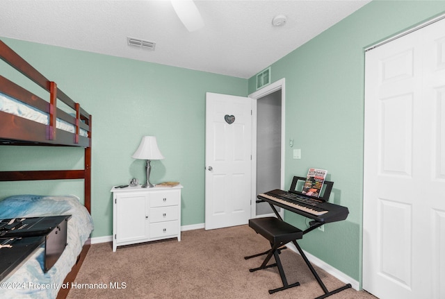 carpeted bedroom featuring a textured ceiling and ceiling fan