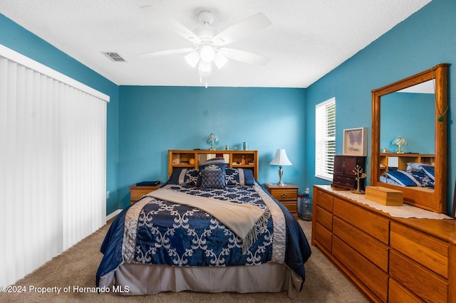 bedroom featuring a textured ceiling, carpet flooring, and ceiling fan