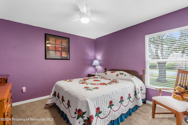 bedroom with ceiling fan, a textured ceiling, and light carpet