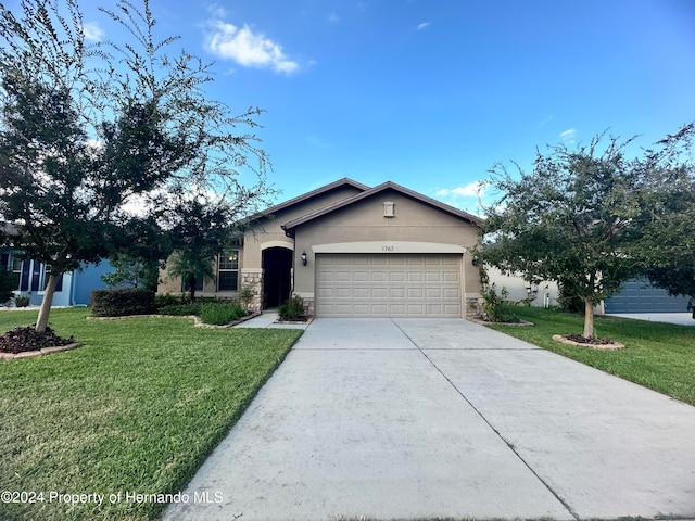 ranch-style home with a garage and a front yard