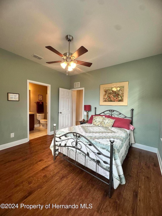 bedroom featuring hardwood / wood-style flooring, ceiling fan, and connected bathroom