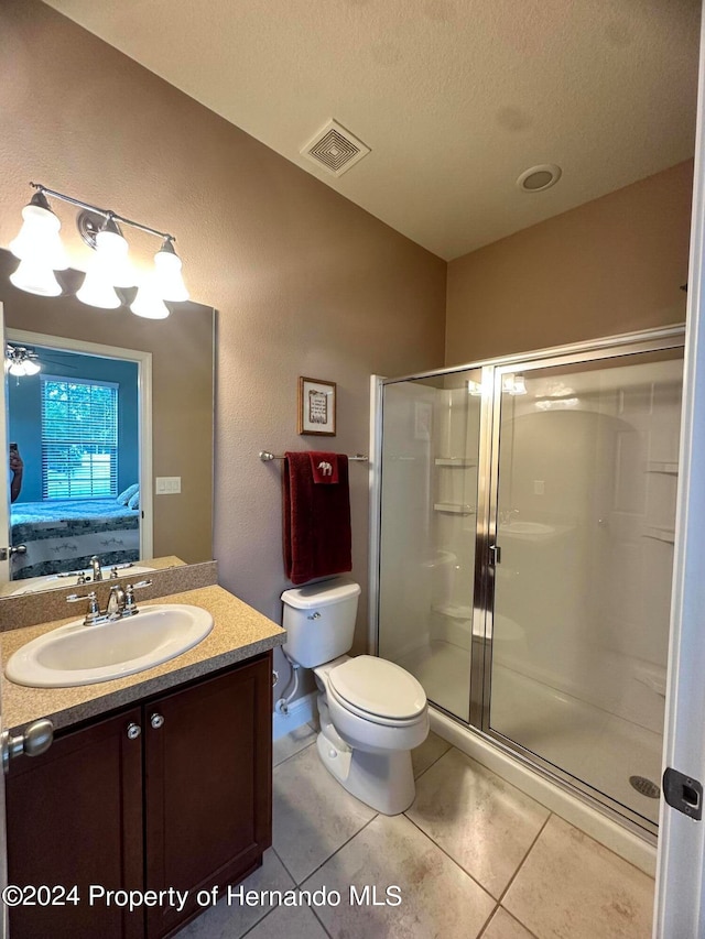 bathroom with toilet, a shower with door, tile patterned flooring, a textured ceiling, and vanity