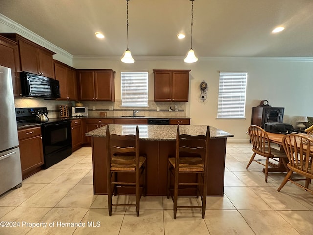 kitchen featuring sink, black appliances, ornamental molding, decorative light fixtures, and a kitchen island