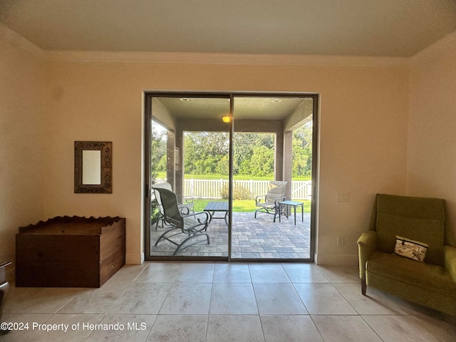 doorway featuring a wealth of natural light, light tile patterned floors, and ornamental molding