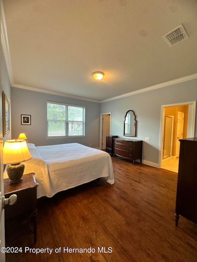 bedroom featuring a textured ceiling, wood-type flooring, and crown molding