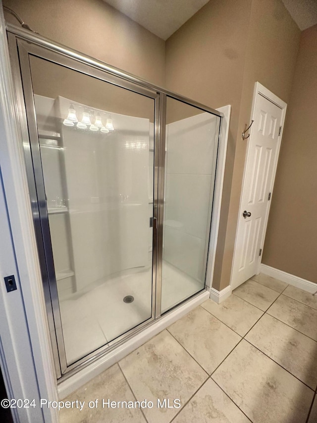 bathroom featuring tile patterned flooring and a shower with shower door