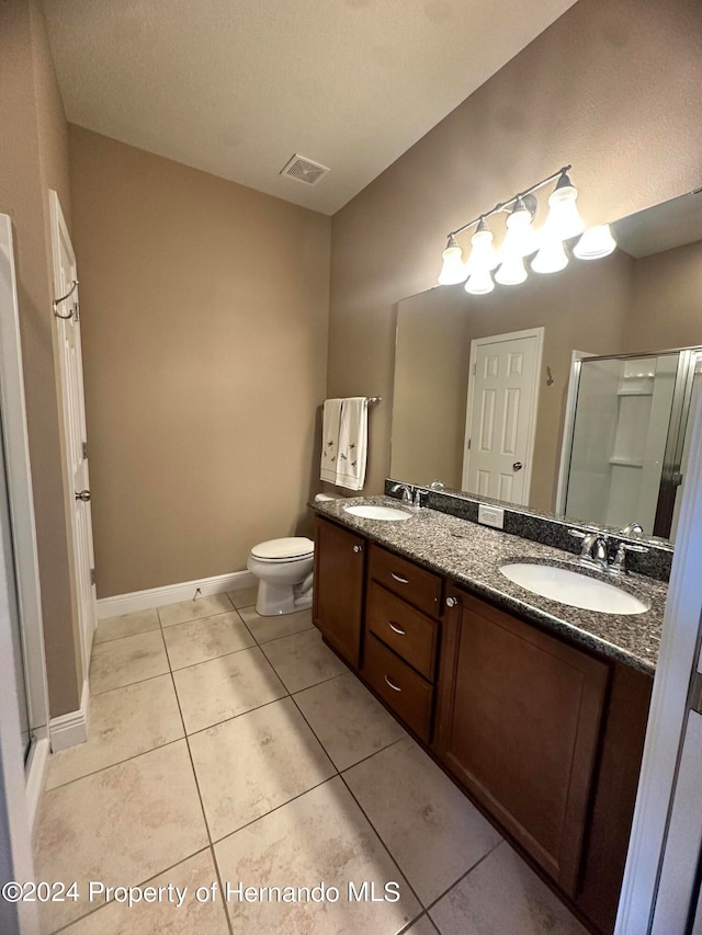 bathroom with walk in shower, vanity, toilet, and tile patterned flooring