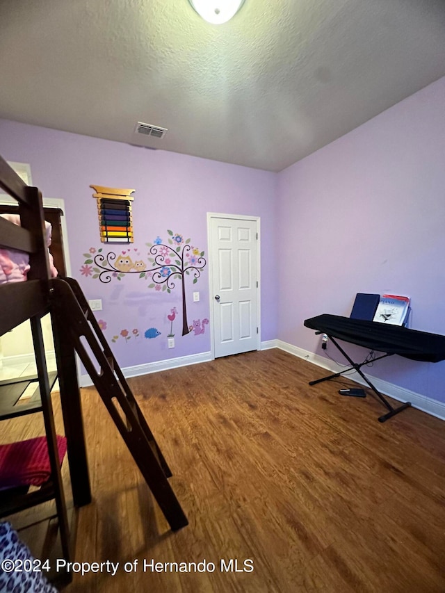 bedroom featuring wood-type flooring and a textured ceiling