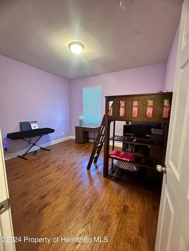 bedroom featuring wood-type flooring and a textured ceiling