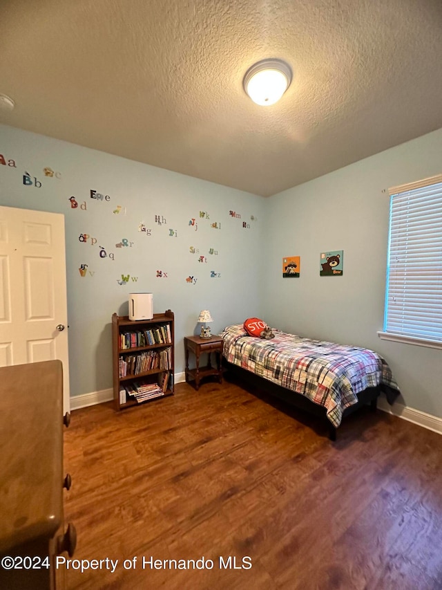 bedroom with wood-type flooring and a textured ceiling