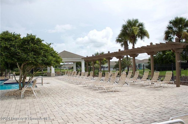 view of community with a swimming pool and a pergola