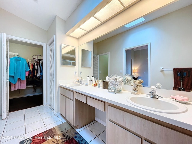 bathroom with tile patterned flooring, vanity, and a skylight