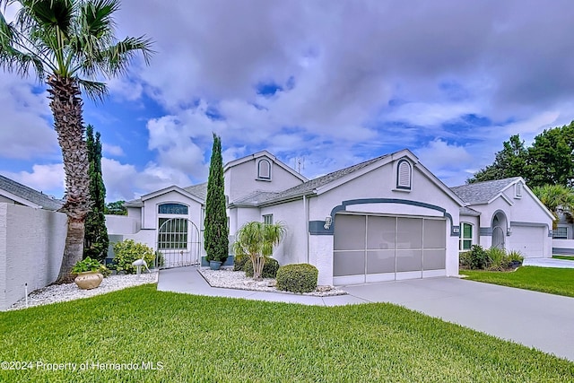 ranch-style house featuring a front lawn and a garage