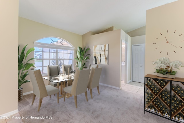 dining space featuring vaulted ceiling and light carpet