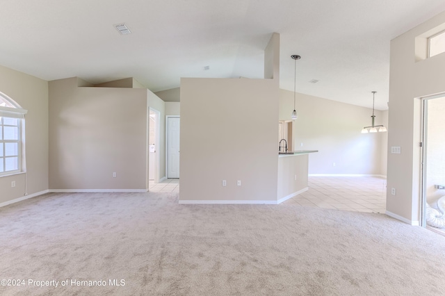 carpeted spare room featuring high vaulted ceiling and sink